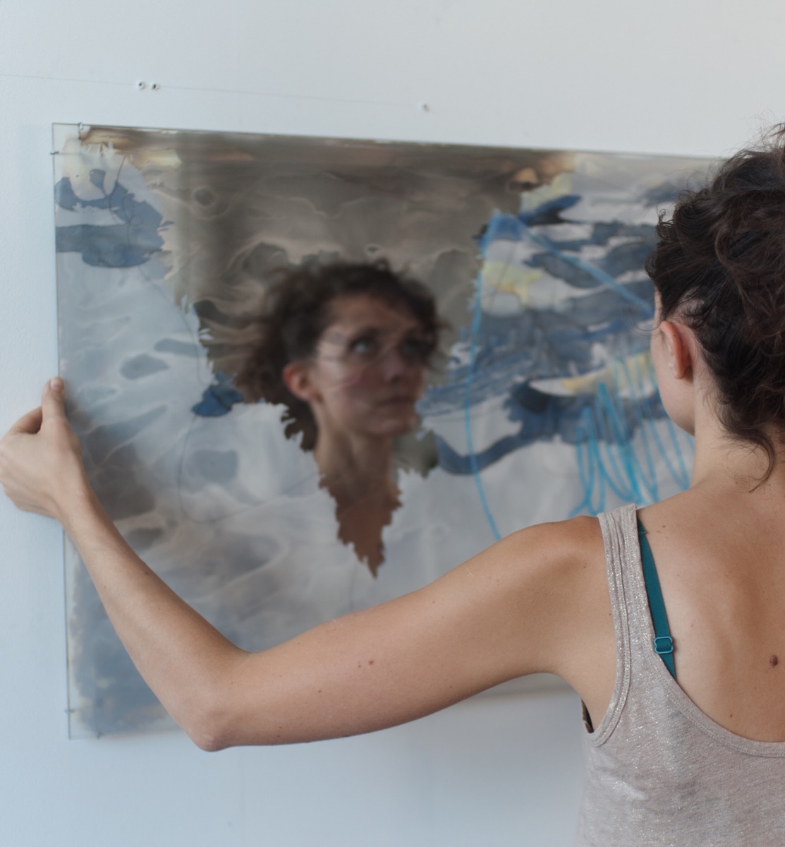 An artist’s face reflected in a mirrored artwork, photographed by Hope.